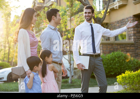 Happy young family and real estate agent Stock Photo