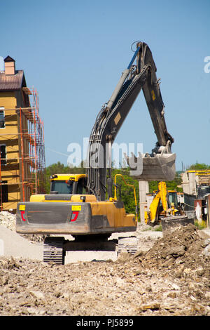 Bucket of a hydraulic excavator collects the rubble after a demolition ...