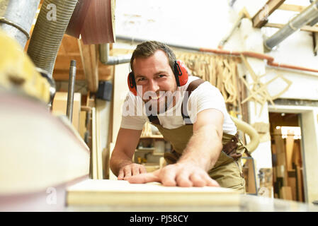 carpenter works in a joinery - workshop for woodworking and sawing Stock Photo
