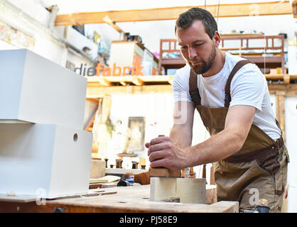 carpenter works in a joinery - workshop for woodworking and sawing Stock Photo