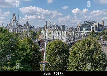 Hungerford bridge and Charing Cross station from the top of the Festival Hall. This side of the station is a Post Modern building by Terry Farrell. Stock Photo