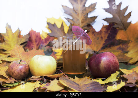 Fresh apple juice on table with apples and maple leaves. Autumn Abstraction Stock Photo