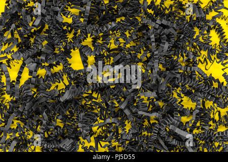 Bunch of shredder black curly carton paper strips background placed on yellow background Stock Photo