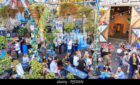 Pop Brixton, people enjoying drinks and food at the cafes, bars and restaurants of the outdoor pop up venue in Brixton, Lambeth, London Stock Photo