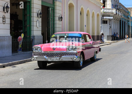 Pink American classic car, 1950s Ford driving, street scene in Matanzas, Cuba