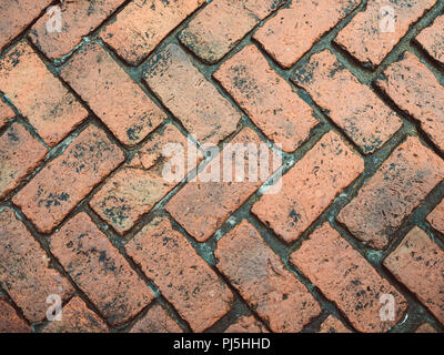 Old orange bricks tiled floor with zigzag pattern texture background. Stock Photo