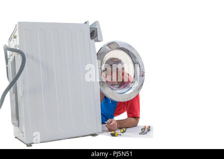 plumbing. Plumber repairing washing machine on white background Stock Photo