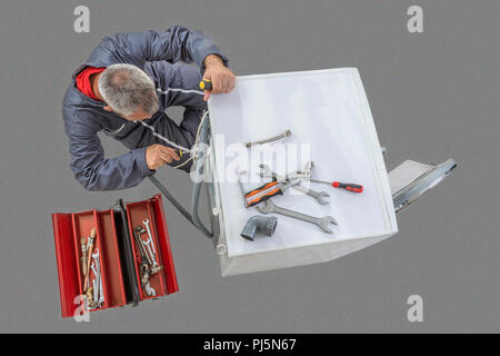 plumber. Technician repairing a washing machine top view grey background Stock Photo