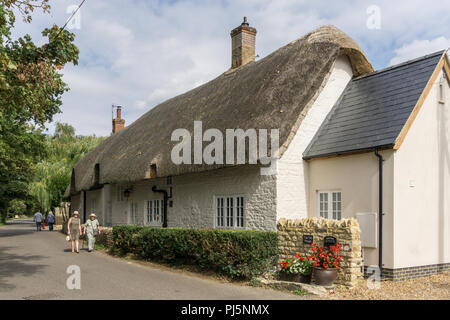 An attractive thatched house in the village of Alderton, Northamptonshire, UK; called the Old plough, it was formerly a pub. Stock Photo