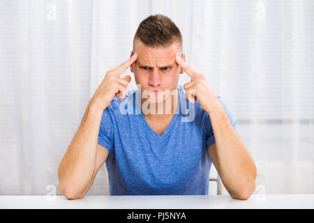 Young man is having strong headache. Stock Photo