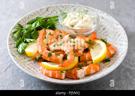 Grilled shrimps, parsley and lemon on gray stone Stock Photo