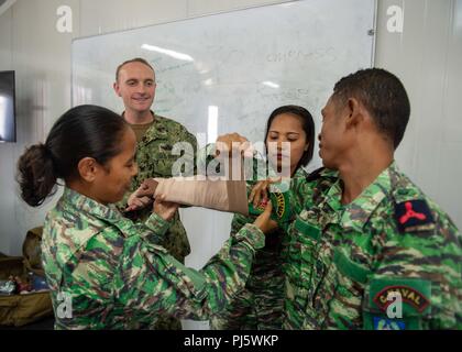 Hospital Corpsman 3rd Class Tom McCarthy, from McKinleyville, California, assigned to Naval Hospital Yokosuka, and members of the National Police of Timor-Leste and the Timor-Leste Defense Force apply a splint during CARAT Timor-Leste 2018 at Hera Naval Base, Aug. 28, 2018. CARAT Timor-Leste 2018 is designed to address shared maritime security concerns, build relationships and enhance interoperability among participating forces. (U.S. Navy photo by Mass Communication Specialist 3rd Class Danny Ray Nuñez Jr./Released) Stock Photo