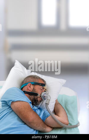 APNEA. Man with sleeping apnea and CPAP machine Stock Photo