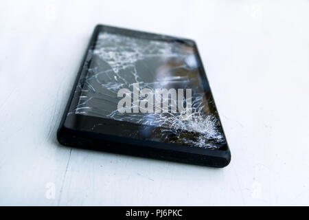 Modern mobile smart phone with broken cracked screen isolated on white background, close up. Stock Photo