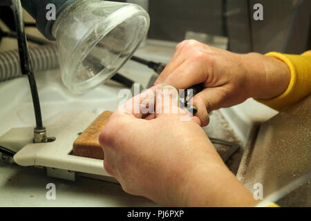 Dentures and dentistry. Dental prosthesis, dentures, prosthetics work. Dental technician in pricess of making dentures. Hands of dental technician. Stock Photo