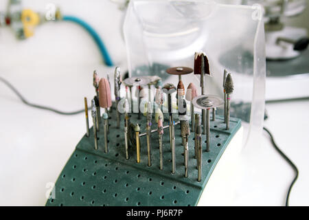 Different dental tools and burs. Dentures and dentistry. Dental prosthesis, dentures, prosthetics work. Dental technician in process of making denture Stock Photo