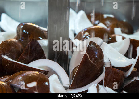 a stream of water on the coconuts on the market. Stock Photo