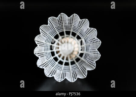 white shuttlecock in the center close-up on black background. Stock Photo