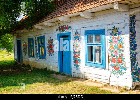 Zalipie, Poland, August 19, 2018:  Colourful house with flowers painted on walls and sundial in the village of Zalipie, Poland. It is known for a loca Stock Photo