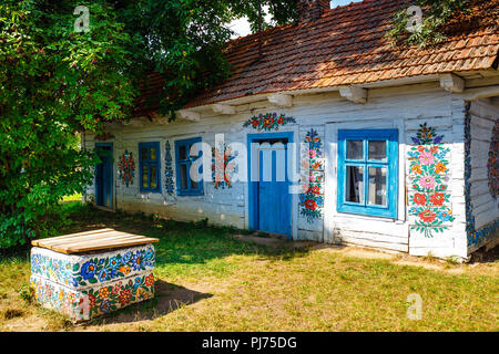 Zalipie, Poland, August 19, 2018:  Colourful house with flowers painted on walls and sundial in the village of Zalipie, Poland. It is known for a loca Stock Photo