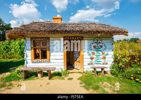 Zalipie, Poland, August 19, 2018:  Colourful house with flowers painted on walls and sundial in the village of Zalipie, Poland. It is known for a loca Stock Photo