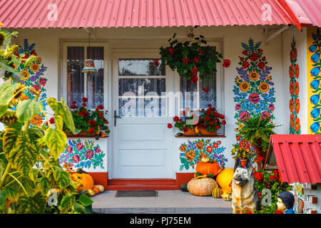 Zalipie, Poland, August 19, 2018:  Colourful house with flowers painted on walls and sundial in the village of Zalipie, Poland. It is known for a loca Stock Photo