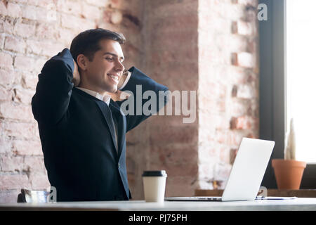 Man working and relaxing in office, end of working day Stock Photo