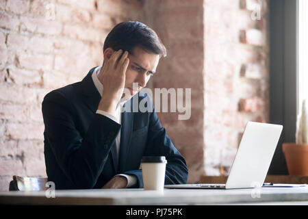 Tired businessman having a headache in office Stock Photo