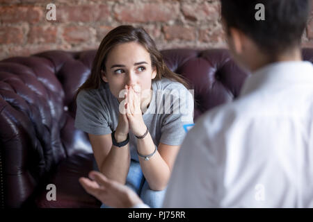 Unhappy young girl visiting at the psychologist Stock Photo