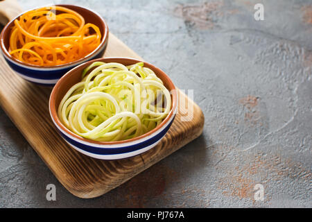 Butternut squash and courgette, zucchini pasta on the grey stone background, selective focus, copy space for text Stock Photo