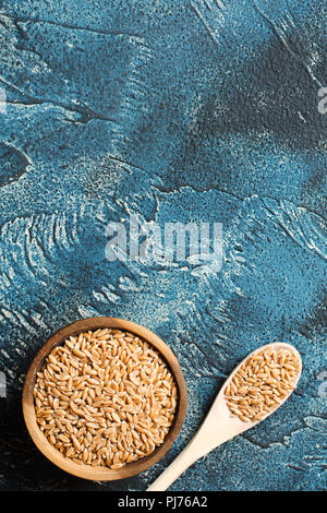Spelt on the dark blue stone table, top view, selective focus Stock Photo