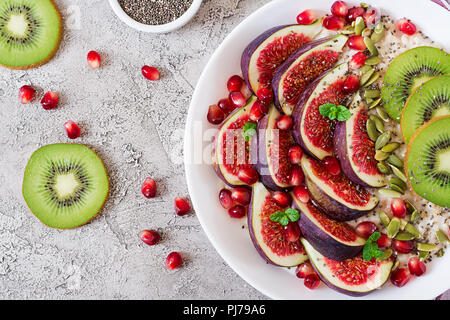 Delicious and healthy oatmeal with figs, kiwi and pomegranate. Healthy breakfast. Fitness food. Proper nutrition. Flat lay. Top view. Stock Photo