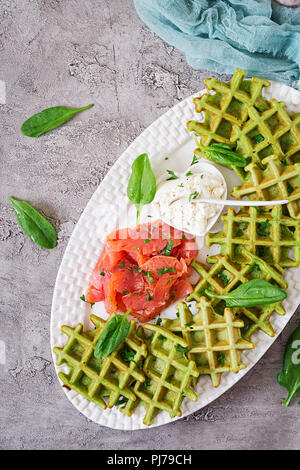 Savory waffles with spinach and cream cheese, salmon in white plate. Tasty food. Top view. Flat lay Stock Photo