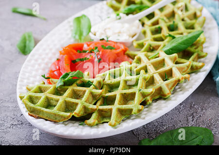 Savory waffles with spinach and cream cheese, salmon in white plate. Tasty food. Stock Photo