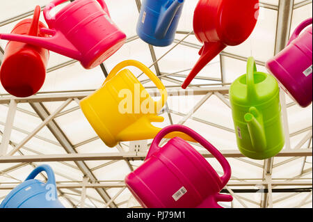 Colourful plastic watering cans on display garden centre Stock Photo