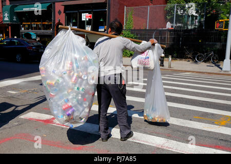 An Asian person carrying bags of recyclable bottles, and cans on a shoulder pole. Many people, especially elderly Chinese, are dependent on the ... Stock Photo