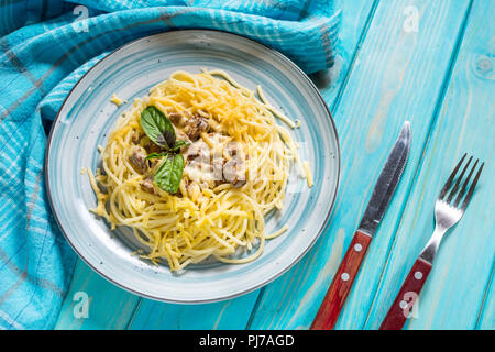 Pasta with chanterelle mushroom and ingredients on blue wooden background. Stock Photo