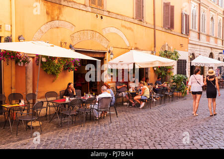 Tourists seated outside a typical bar in the Trastevere district, Lazio, Rome, Italy. Stock Photo