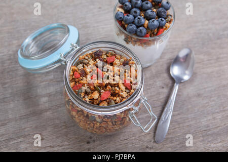 Paleo granola made with mixed nuts, seeds, raisins with coconut yogurt, blueberries on the top, selective focus Stock Photo