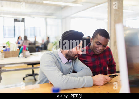 Businessmen using smart phone in office Stock Photo