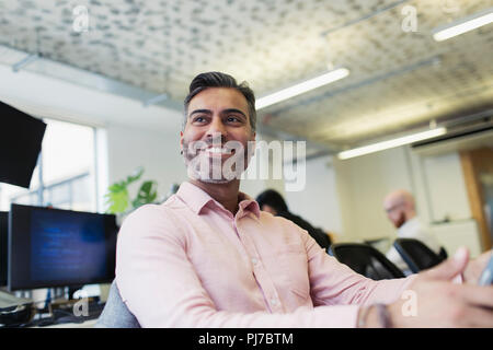 Smiling, confident businessman working in office Stock Photo