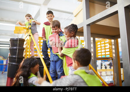 Kids playing with toy bricks at interactive construction exhibit in science center Stock Photo