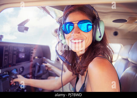 Portrait smiling, confident young woman flying airplane Stock Photo