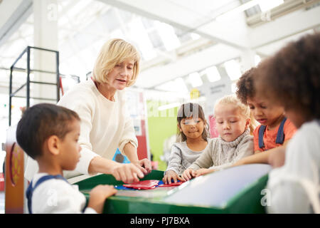 Teacher and students at interactive exhibit in science center Stock Photo