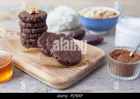 Raw vegan paleo style cookies, made with nuts, coconut oil, honey and dates, selective focus on the nearest cookie Stock Photo