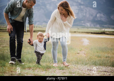 Parents walking with baby son in rural field Stock Photo