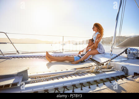 Serene, affectionate couple relaxing on sunny catamaran Stock Photo