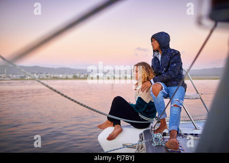 Young couple relaxing on boat at sunset Stock Photo