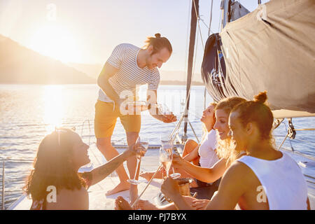 Friends drinking champagne on sunny catamaran Stock Photo