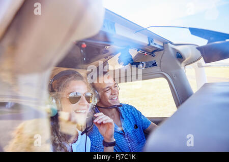 Happy pilot and copilot couple flying airplane Stock Photo